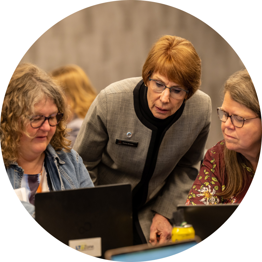 Three women consult laptop